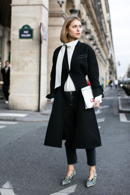 With white turtleneck, black midi coat, jeans and clutch