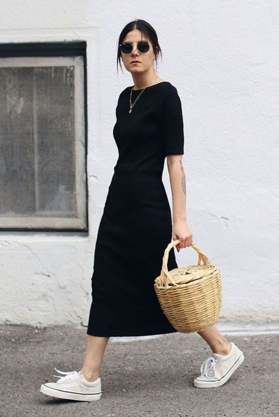 a black fitting minimalist midi dress with a high neckline and short sleeves, white sneakers for a monochromatic look