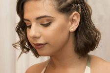 a boho half updo with a side braid and hair piercings and waves down is a super bold and catchy idea