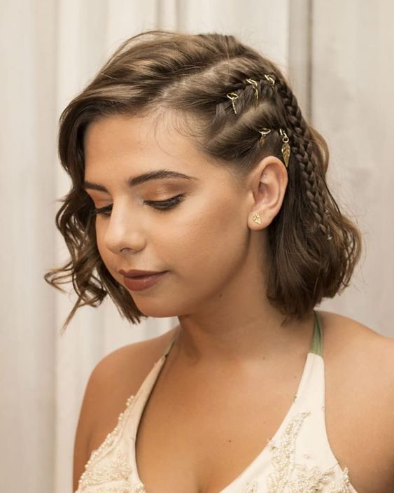 a boho half updo with a side braid and hair piercings and waves down is a super bold and catchy idea