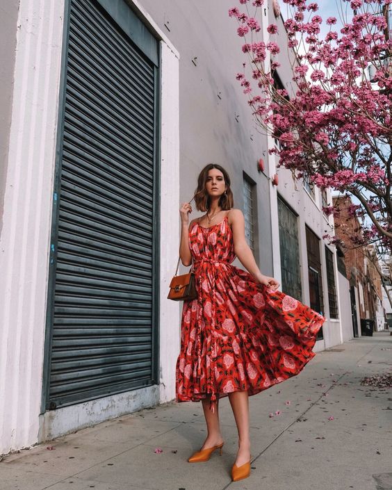 a bright red and pink printed midi dress on spaghetti straps, with a midi skirt, tan mules and a vintage bag