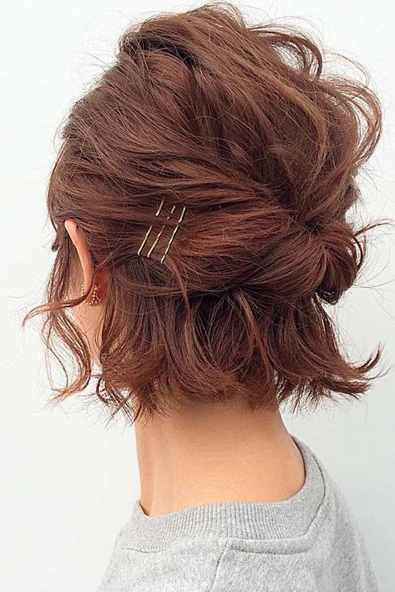 a emssy and textural burgundy midi bob styled with a bump on top and some twists plus bobby pins is cool