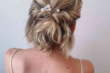 a half updo with a bump on top and twists and waves and pearl hair pins is a cool idea for a party outfit