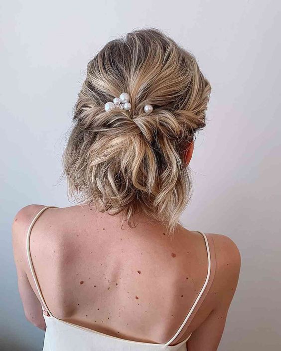 a half updo with a bump on top and twists and waves and pearl hair pins is a cool idea for a party outfit