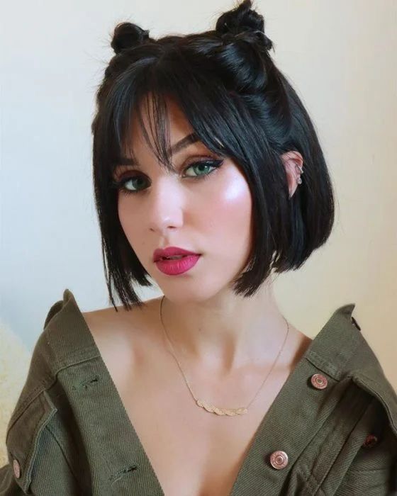 A jaw line bob with cute top knots and wispy bangs is a stylish idea to look cute
