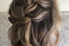a loose braided halo half updo with waves and some volume is a chic and lovely idea for a boho look