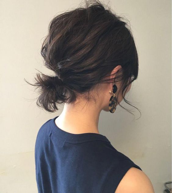 a messy low ponytail with a volumetric bump on top and some side bangs is a cool and lovely idea for short hair