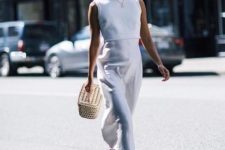 a minimalist white fitting midi dress with a high neckline, no sleeves, blue shoes and a basket bag