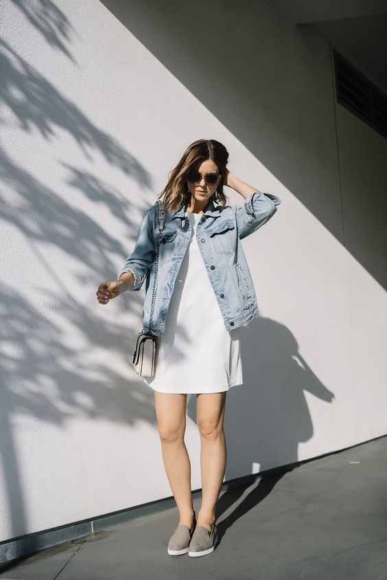 a minimalist white mini dress, a blue denim jacket, grey loafers for a spring to summer look