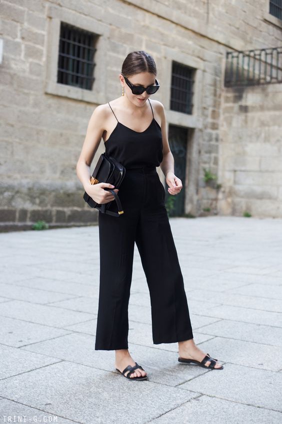 a total black look with a spaghetti strap top, pants, chic slippers and a crossbody bag
