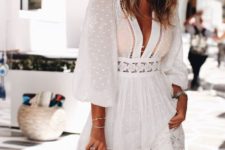 a vacation white mini dress with long puff sleeves, a deep plunging neckline and lace skirt, tan shoes and a bag