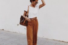 a white tee, rust colored pants, cognac sandals and a large brown bag for a comfy look