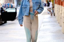 Gigi Hadid wearing a tan crop top, joggers, trainers and a light blue cropped denim jacket