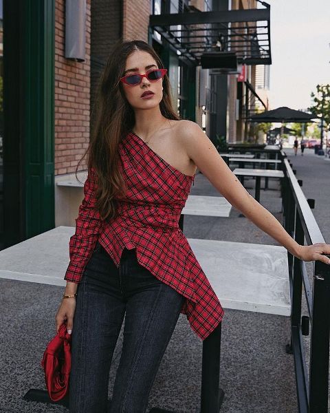 With dark colored skinny jeans and red framed sunglasses