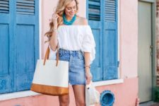 With white off the shoulder blouse, white and brown tote bag, white hat and gray sandals