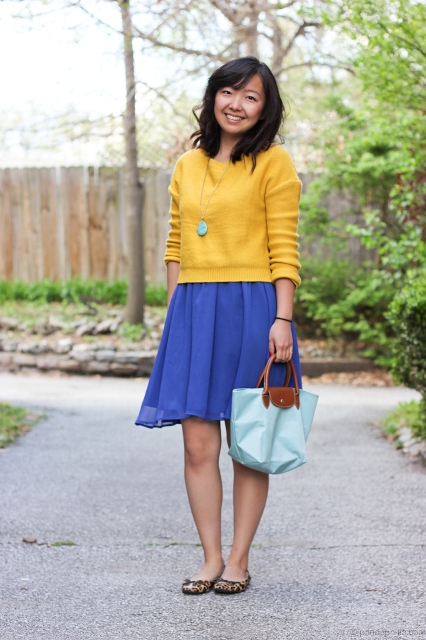 With yellow sweatshirt, blue skirt and leopard flat shoes