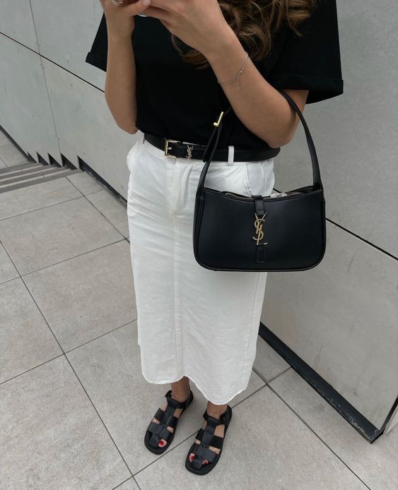 a black and white look with a t-shirt, a denim midi skirt, trendy sandals, a black baguette bag for summer