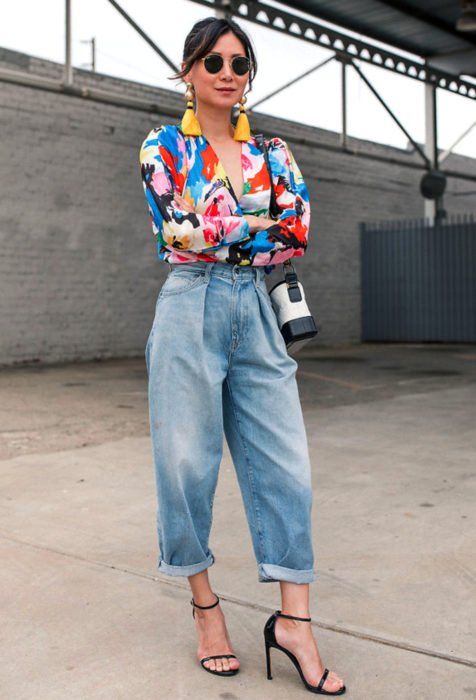 a bold and trendy look with a colorful short, baggy jeans, black heels and tassel earrings