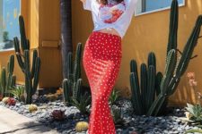 a bright summer outfit with a white printed tee, a red polka dot fitting midi skirt, white sneakers