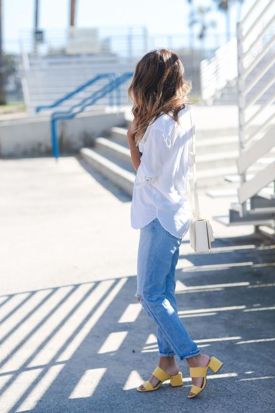 a casual look with a white shirt, blue jeans, sunny yellow heeled mules for a bold touch and a white bag
