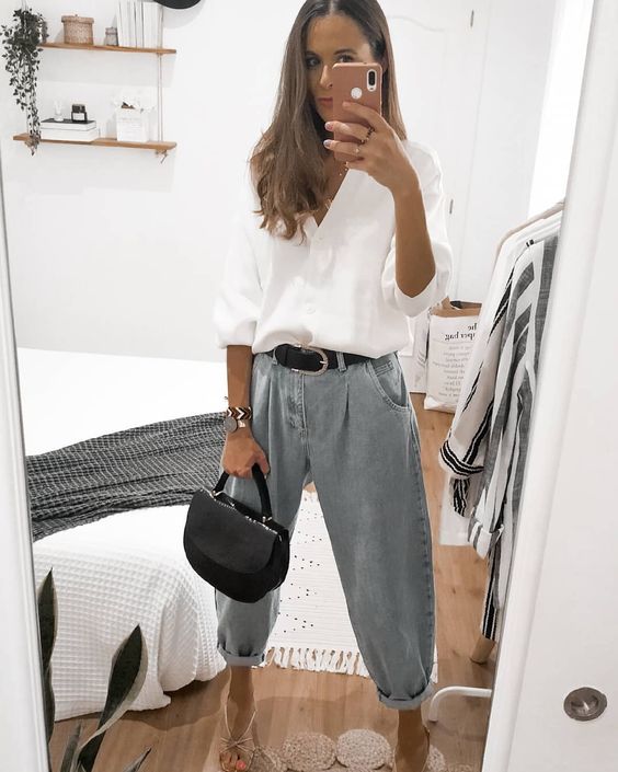 a chic outfit with a white linen shirt, baggy jeans, silver heels and a small black bag