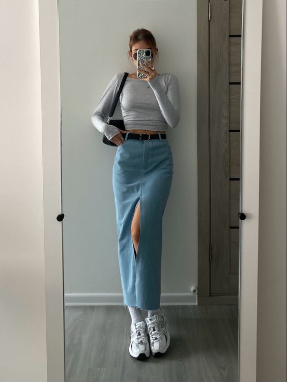 a grey crop top with long sleeves, a blue maxi skirt, white sneakers, a black belt and a black bag are a cool look for spring