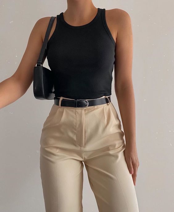 a minimal summer outfit with a black tank top, beige pants, a black belt and a small baguette bag