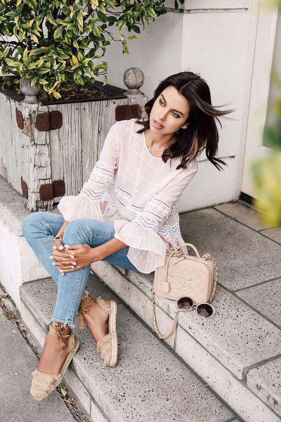 a neutral top with ruffle sleeves, blue skinnies, espadrilles, a blush bag and sunglasses