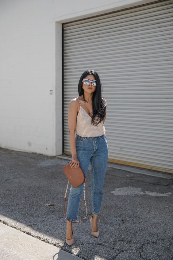 a nude embellished top, blue high waisted jeans, nude pointed toe shoes and a brown crossbody