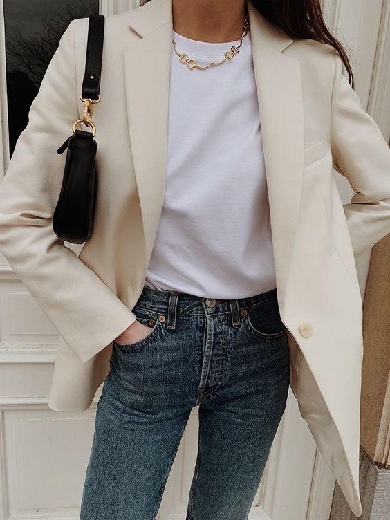 a pretty spring outfit with a white t-shirt, blue jeans, an ivory blazer, a necklace and a small baguette bag
