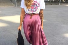 a printed t-shirt, a pink pleated midi skirt, black sneakers and a black bag for a girlish touch