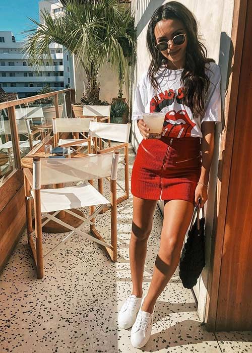 a printed t-shirt, a red mini skirt, white sneakers and a black bag for a bold look