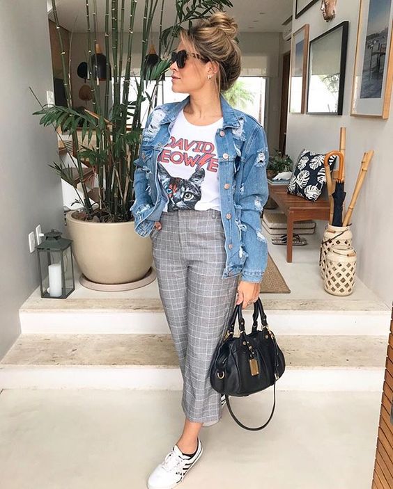 a printed tee, an oversized blue denim jacket, grey printed pants, white sneakers and a black bag