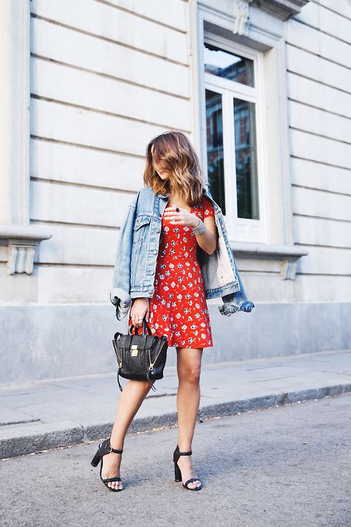 a red printed mini dress, a blue denim jacket, black block heels and a black bag with zips