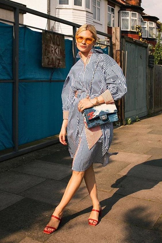 a striped overiszed knee shirtdress, yellow sunglasses, a printed bag and red square toe sandals