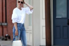 a stylish outfit with a white top with lace ruffle sleeves, blue jeans, tan shoes and a white bag