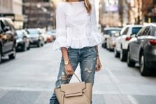 a summer outfit with a white top with ruffle sleeves, blue jeans, white shoes and a neutral bag