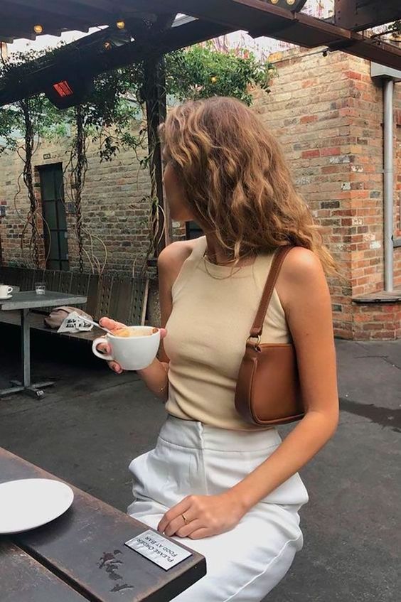 a tan sleeveless top crop, white high waisted pants, a brown baguette bag for an everyday look