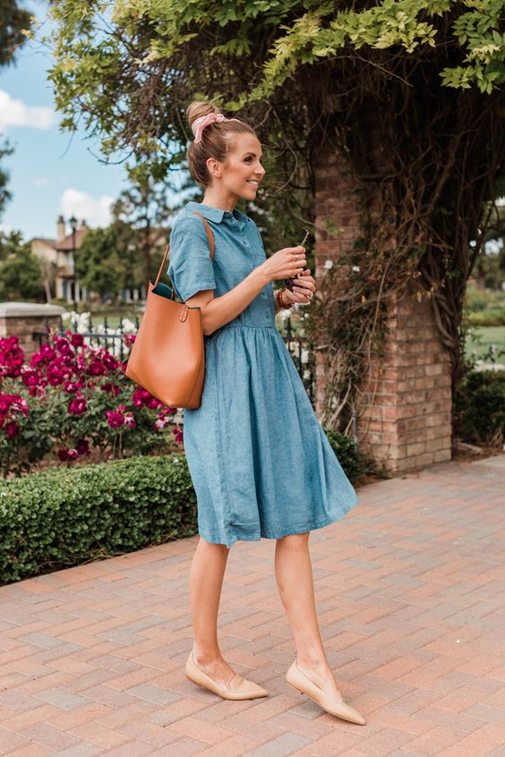 a trendy outfit with a blue denim knee dress, tan pointed toe flats and a brown tote