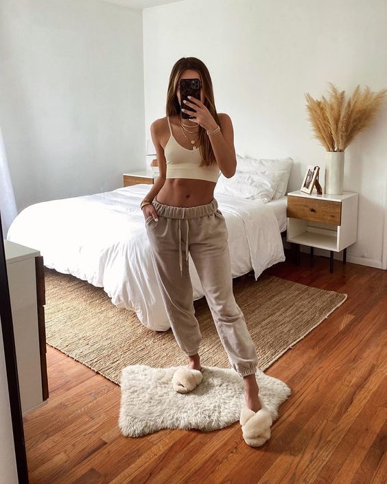 a white crop top, neutral cropped joggers and layered necklaces to look cool and a bit boho