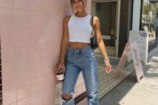 a white halter neckline crop top, blue jeans, white sneakers and a black baguette bag for an edgy look