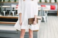 a white over the knee voluminous dress with a ruffle edge, short sleeves, black lace up heels and an animal print clutch