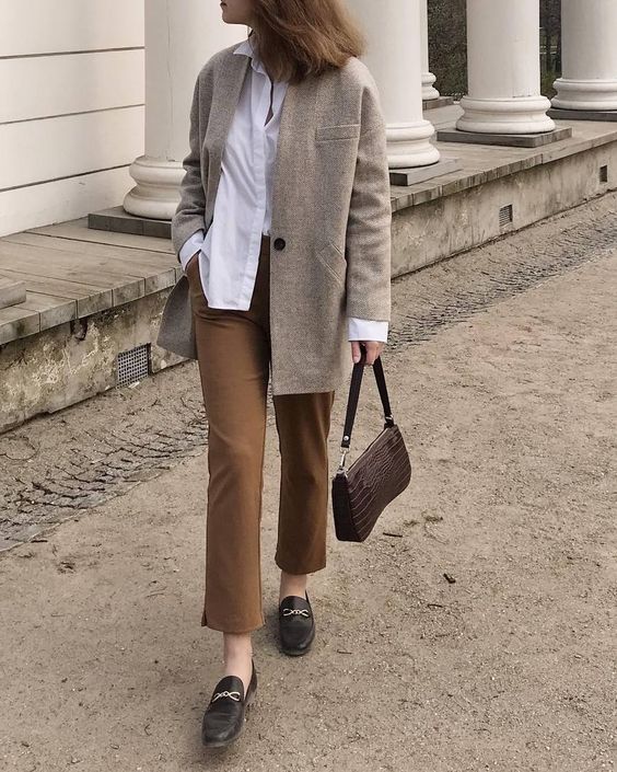 a white shirt, tan cropped pants, a grey oversized blazer, black moccasins and a chocolate brown baguette bag