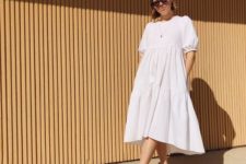 a white voluminous cotton midi dress with a high neckline, puff sleeves and sheer heeled mules