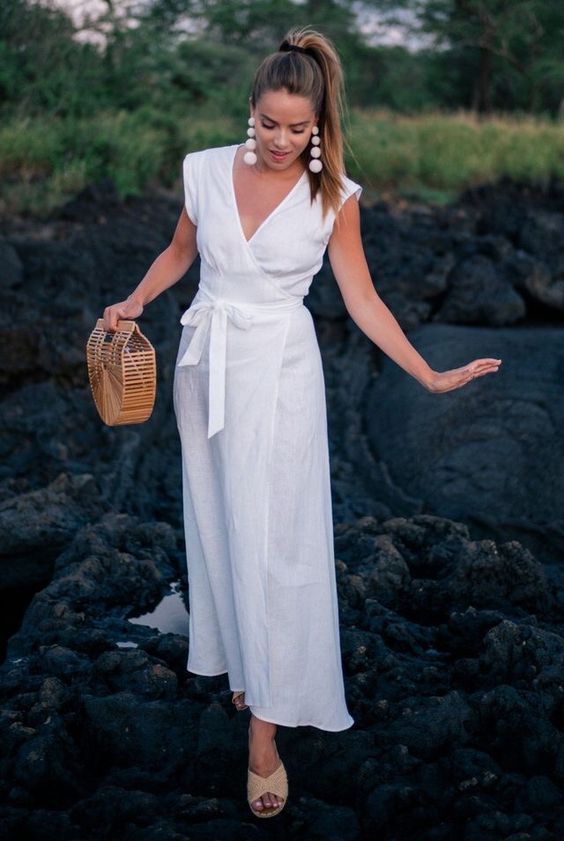 a white wrap midi dress with cap sleeves, a sash, neutral slippers and a basket bag for summer