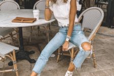 cropped ripped blue skinnies, a white lace crop top with ruffle sleeves, white slipper mules