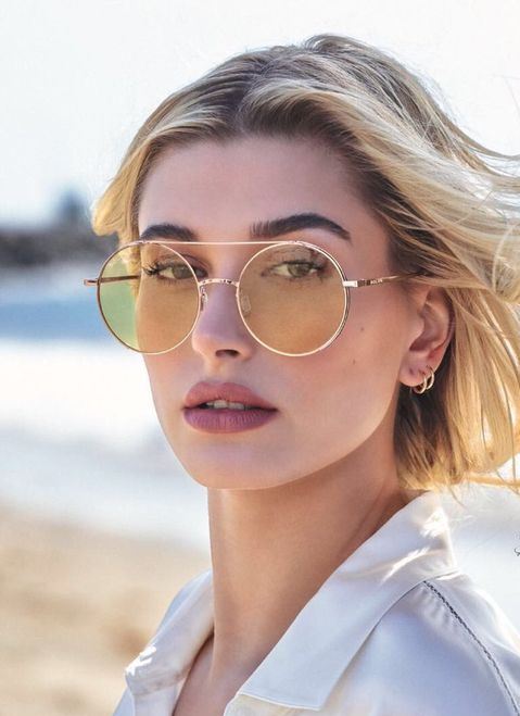 Hailey Baldwin wearing pastel yellow round sunglasses in a gold frame - a fresh take on classics