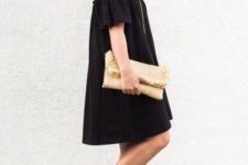 With black off the shoulder loose dress and beige clutch