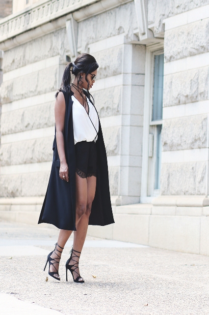 With black shorts, black sleeveless long cardigan and lace up shoes
