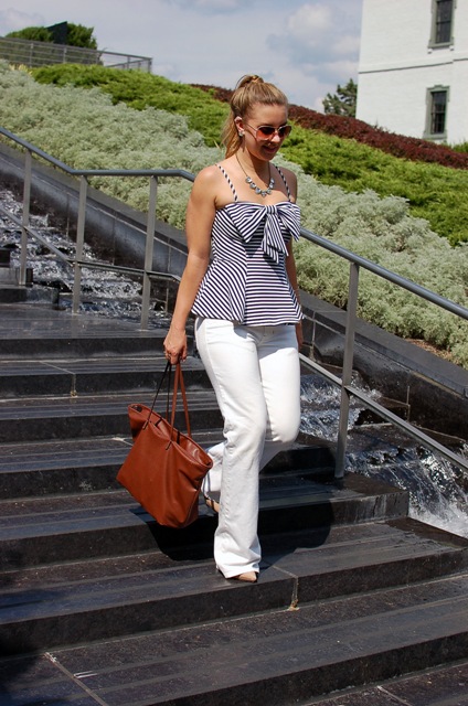 With white flare pants, beige pumps and brown tote bag